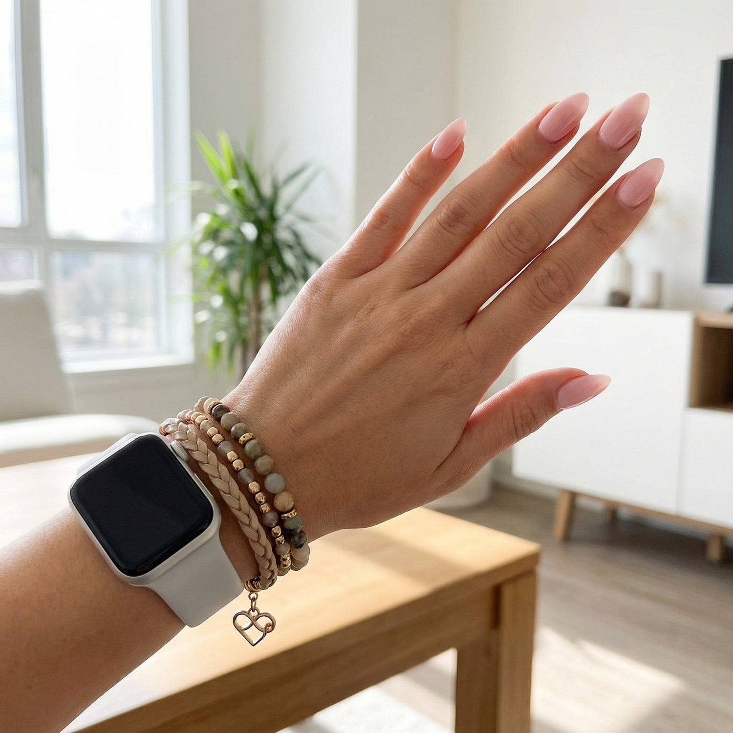 Poignet de femme portant une Apple Watch avec un bracelet multi-rangs bohème chic