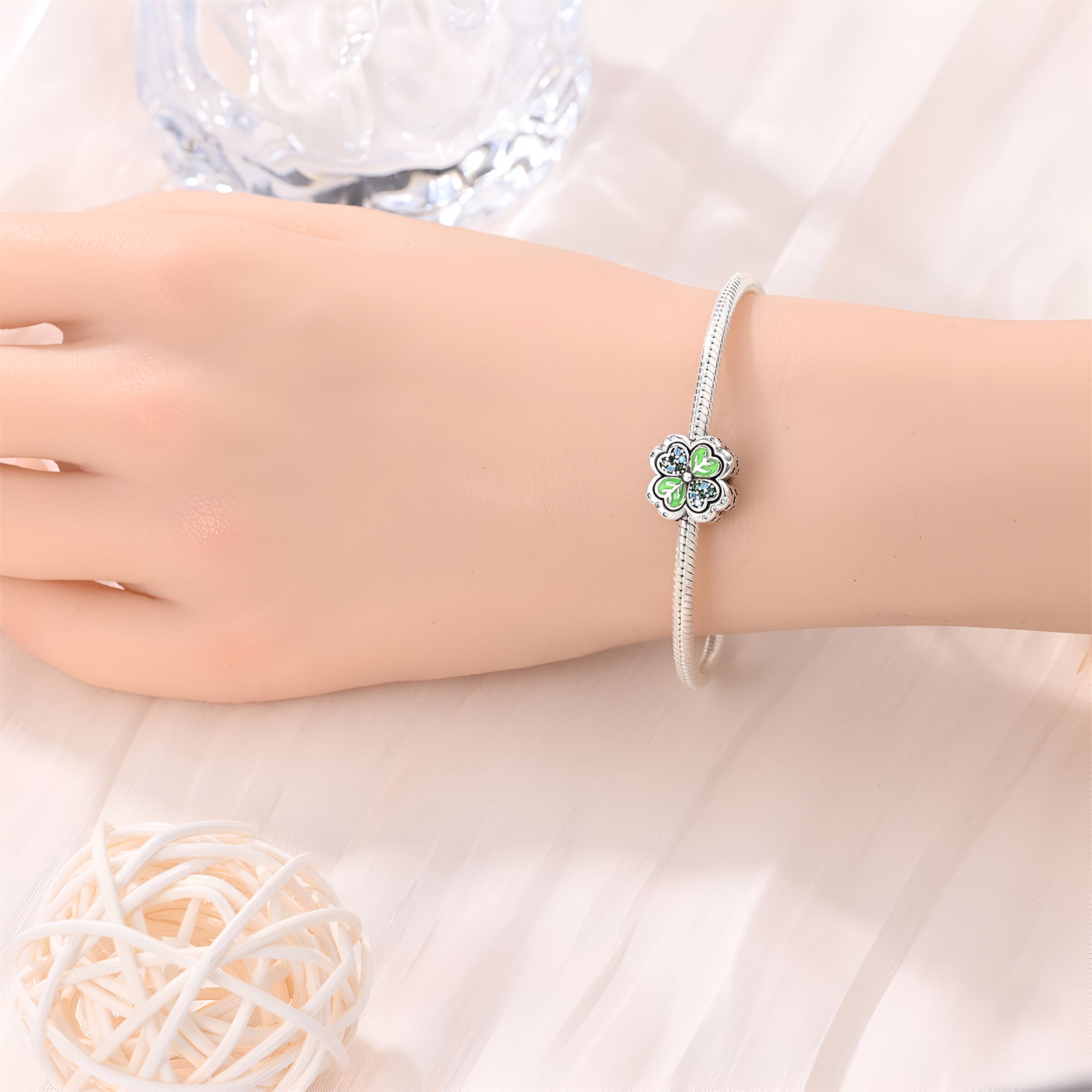Bracelet argent fin avec charm trèfle à 4 feuilles orné de pierres vertes et blanches.