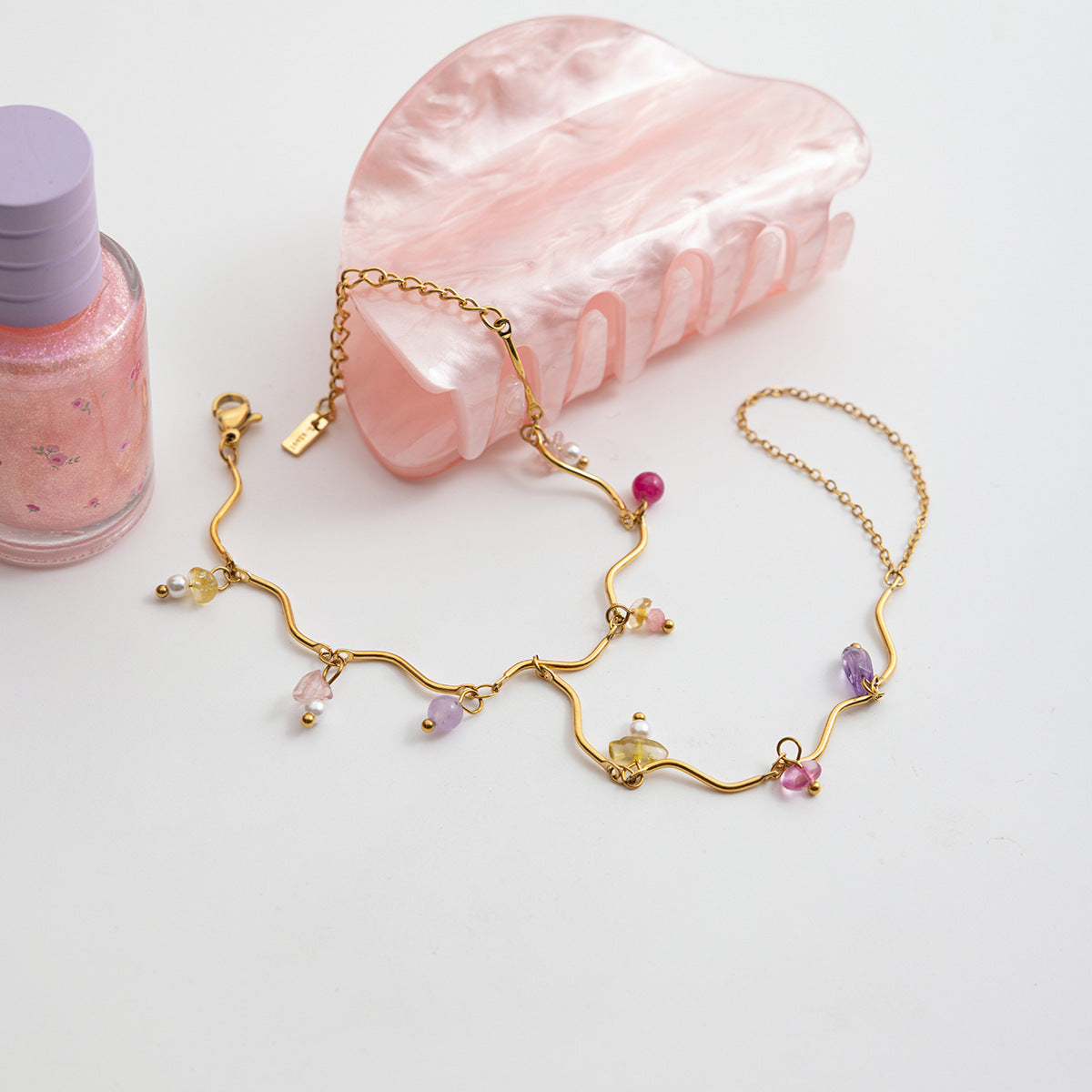 Bracelet de main doré en acier inoxydable avec chaînes fines et pierres naturelles colorées multiformes.