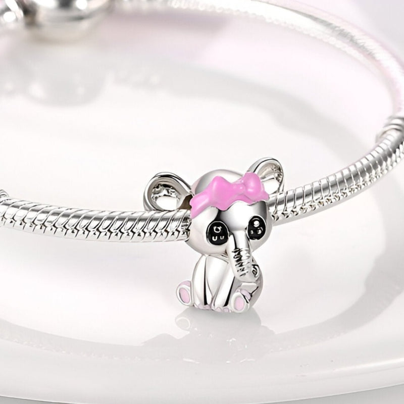 Charm éléphanteau argenté avec nœud rose sur bracelet serpent en argent.