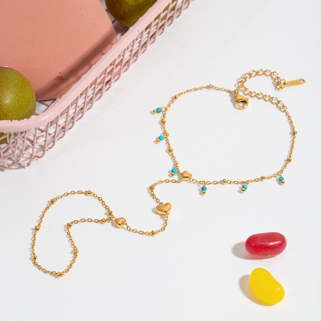 Bijou de main doré en acier inoxydable avec perles turquoise et chaînette en forme de cœur, style délicat.