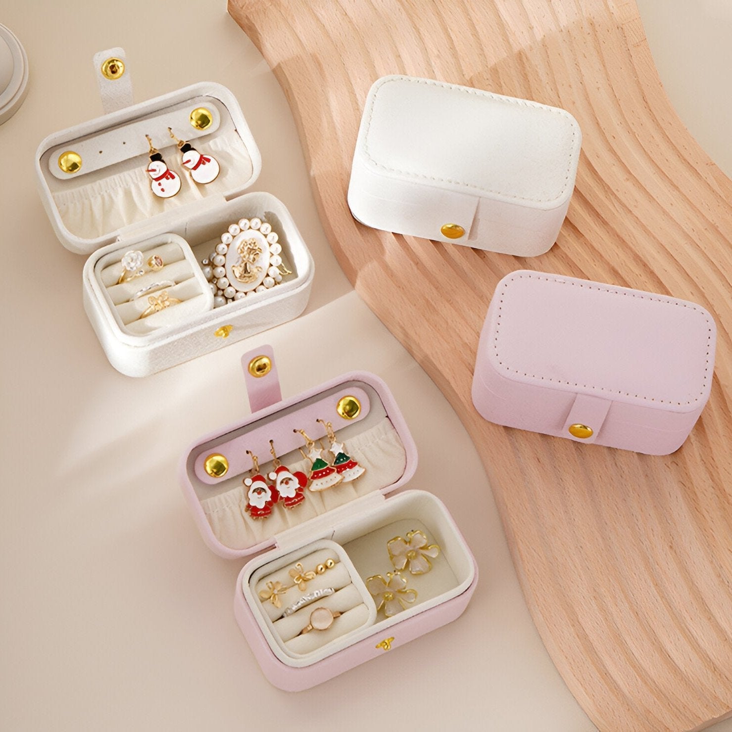 Boîte à bijoux nomade format moyen en cuir blanc et rose, compartiments organisés avec bouton doré.