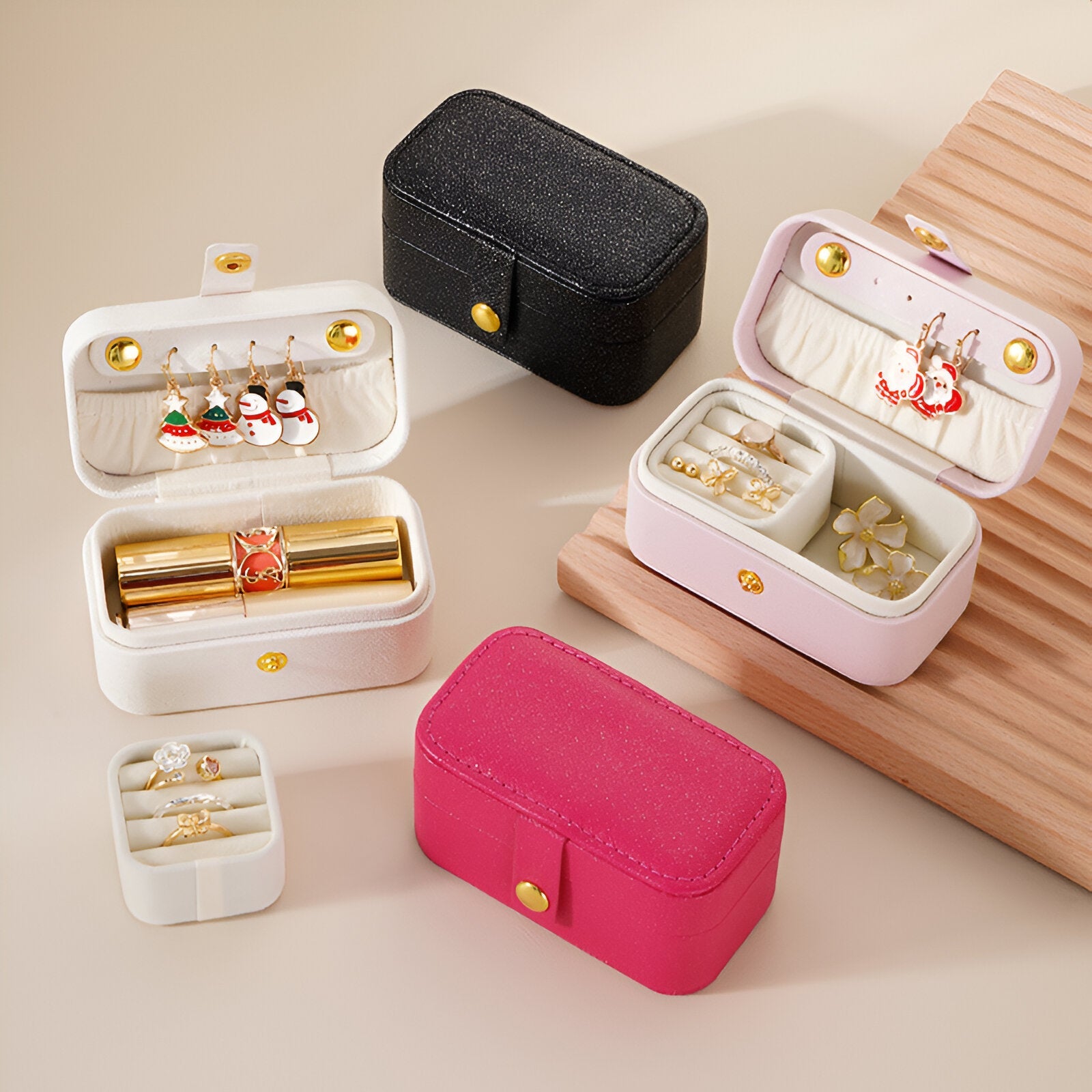 Lot de boîtes à bijoux nomades en cuir grainé, format moyen, couleurs noir, blanc, rose et fuchsia, avec fermoir bouton doré.