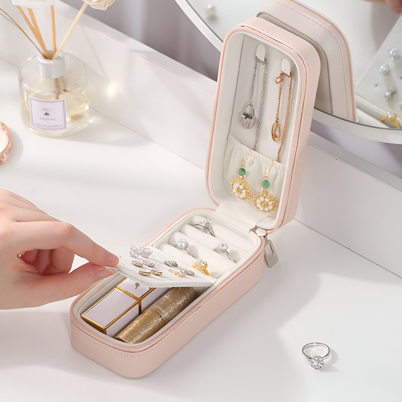 Boîte à bijoux nomade allongée rose en cuir, compartiments multiples avec rangement pour bagues et boucles d’oreilles.