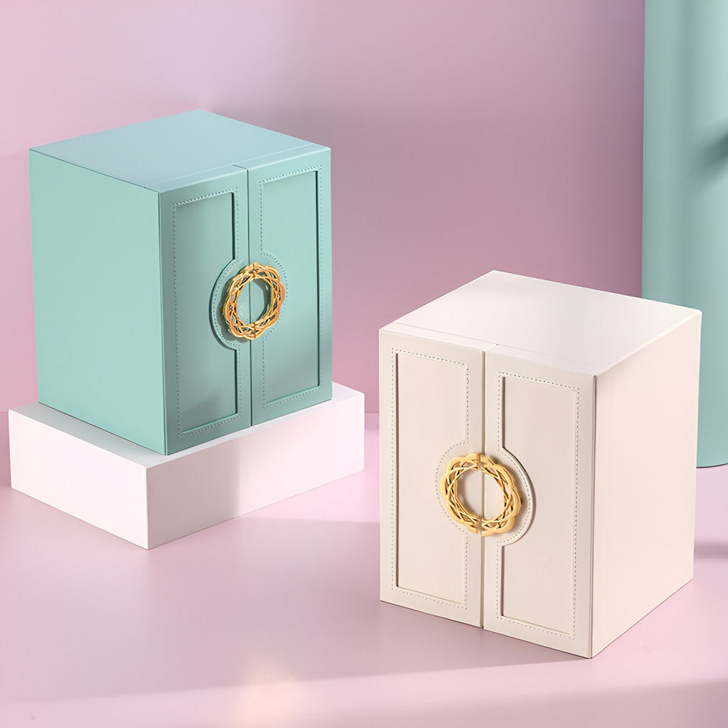 Boîte à bijoux nomade blanche et bleue avec fermoir doré et design contemporain en cube.