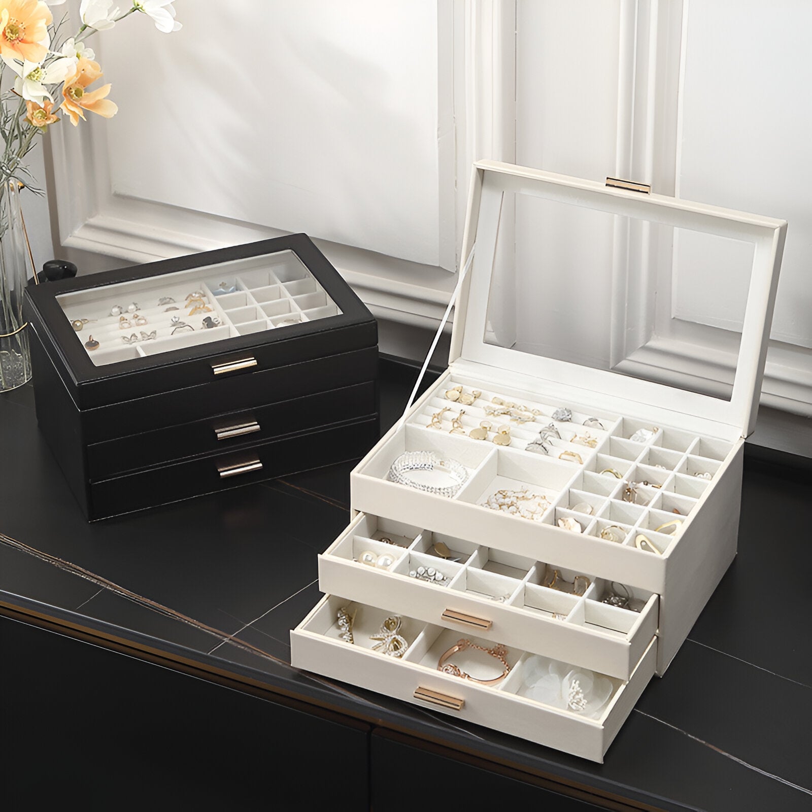 Boîte à bijoux nomade blanche grand format avec multiples tiroirs et compartiments organisés sous couvercle transparent.