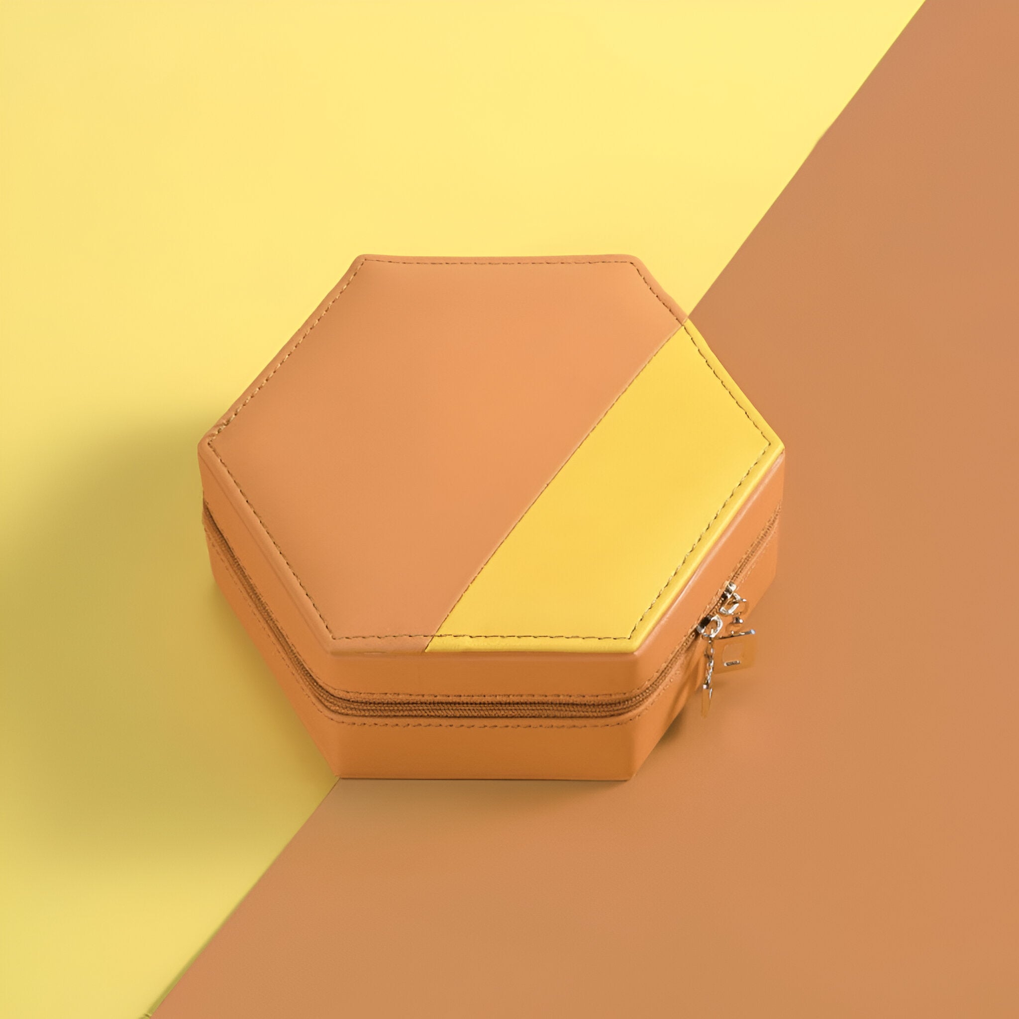 Boîte à bijoux hexagonale en cuir orange et jaune avec fermeture éclair argentée.
