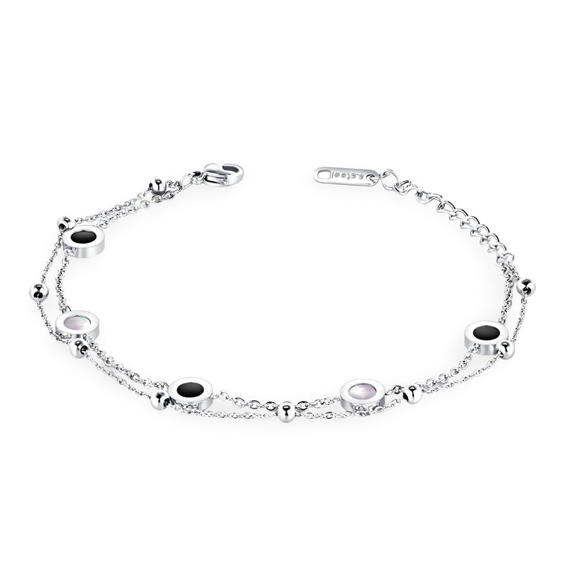 Bracelet fin ajustable en argent avec petits motifs ronds noirs et blancs espacés sur chaîne délicate.