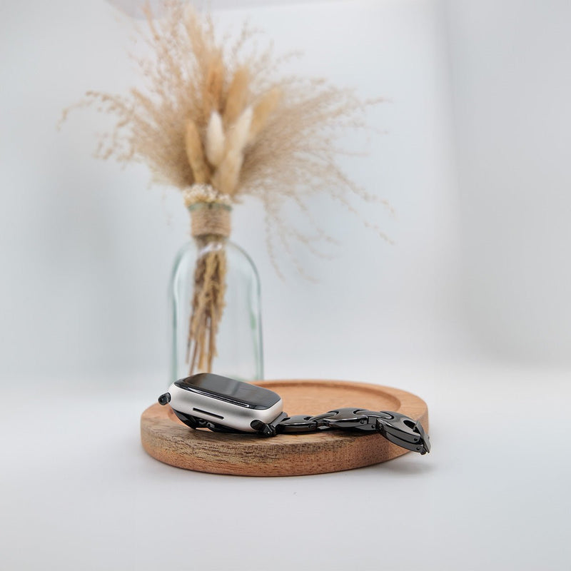 Bracelet Apple Watch femme en mailles acier noir mat, design moderne, fermoir papillon élégant.