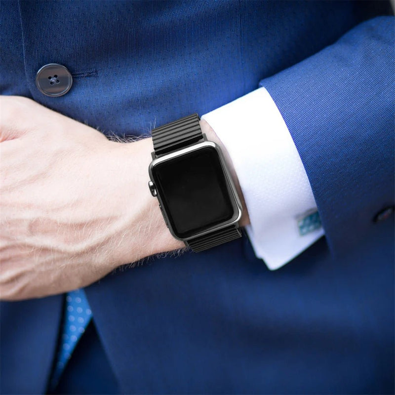 Bracelet Apple Watch à maillons extensibles en acier inoxydable noir, design sans fermoir, porté avec une chemise blanche et