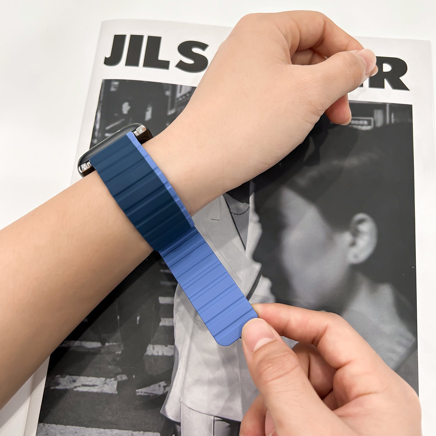 Bracelet Apple Watch silicone bicolore bleu à fermeture magnétique double face, design strié, ajustable au poignet.