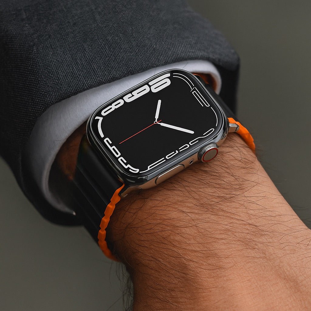 Bracelet Apple Watch silicone bicolore noir et orange avec fermeture magnétique double face, design épuré et ajusté.