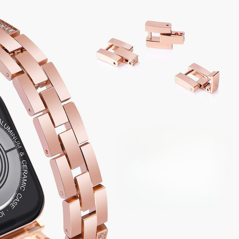 Bracelet pour Apple Watch en métal rose doré avec maillons larges et fermoir déployant, pièces supplémentaires incluses.