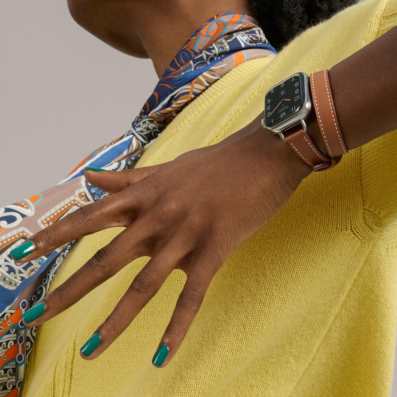 Bracelet Apple Watch en cuir marron à double tour porté sur un poignet féminin.