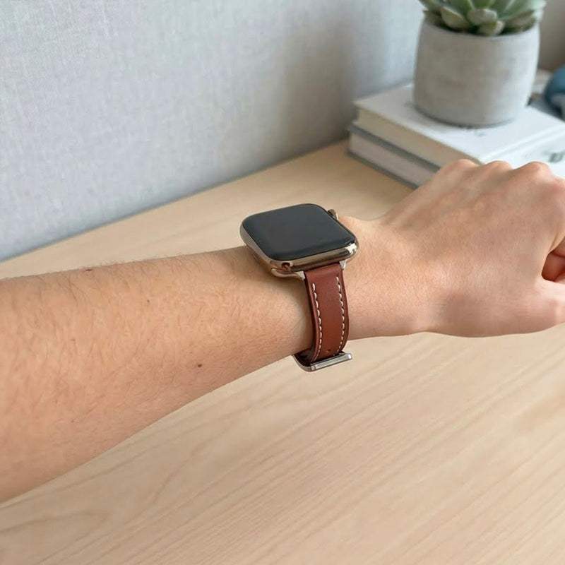 Bracelet Apple Watch en cuir marron avec couture blanche contrastante, style élégant et ajustable.