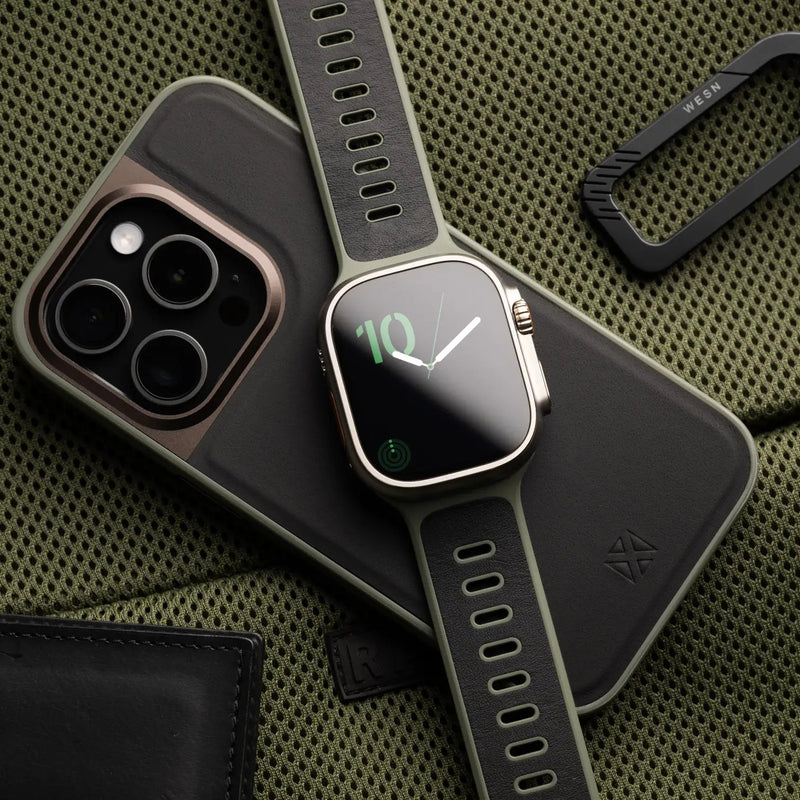 Bracelet Apple Watch hybride en cuir noir et fluoroélastomère gris foncé avec boucle ajustable en métal argenté.