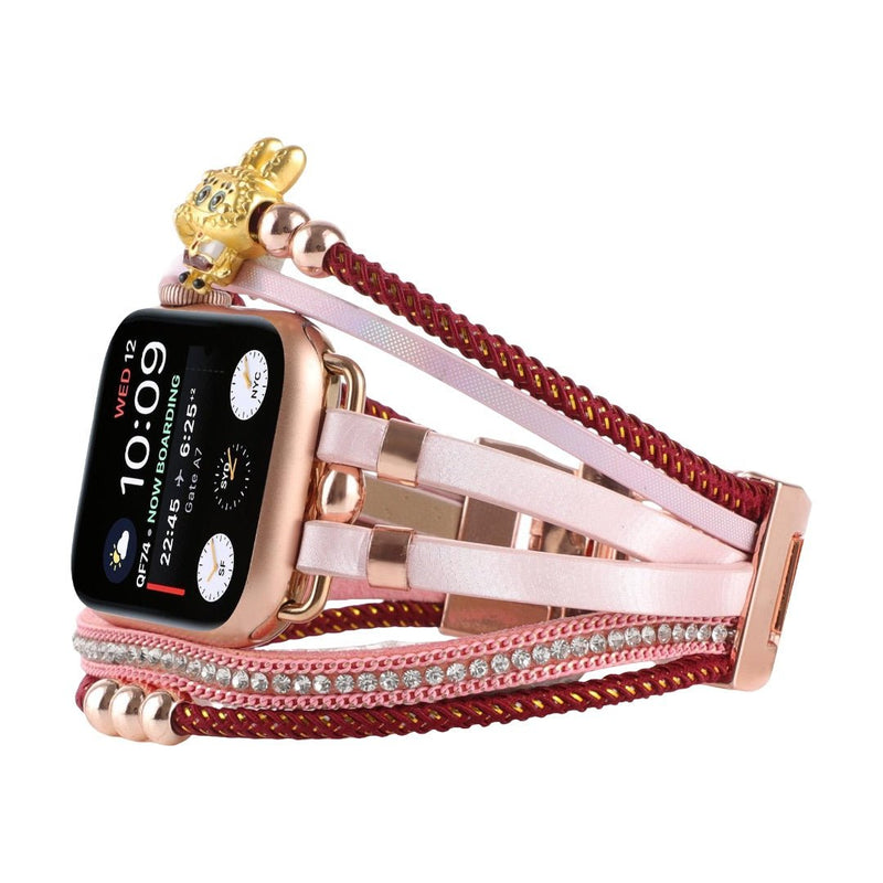 Bracelet doré pour Apple Watch avec perles dorées, strass brillants et breloque ours teddy sur cordon tressé rouge.