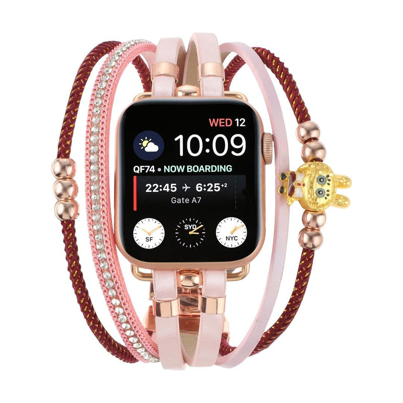 Bracelet Apple Watch doré à plusieurs lanières roses et rouges, avec perles dorées, strass brillants et breloque ourson.