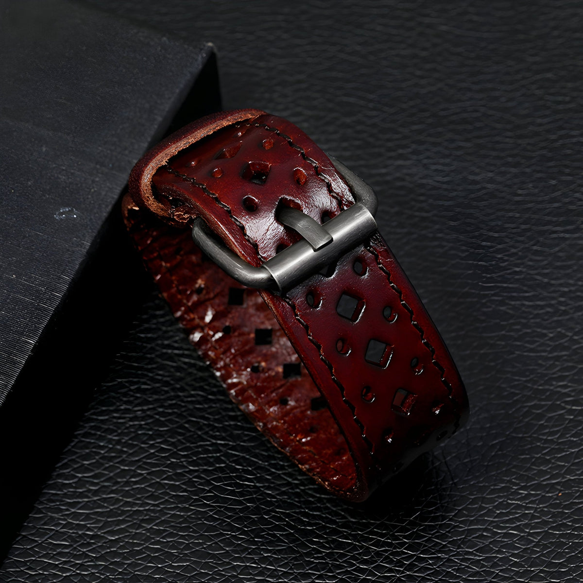 Bracelet homme en cuir cognac à boucle ardillon style rétro avec perforations décoratives.