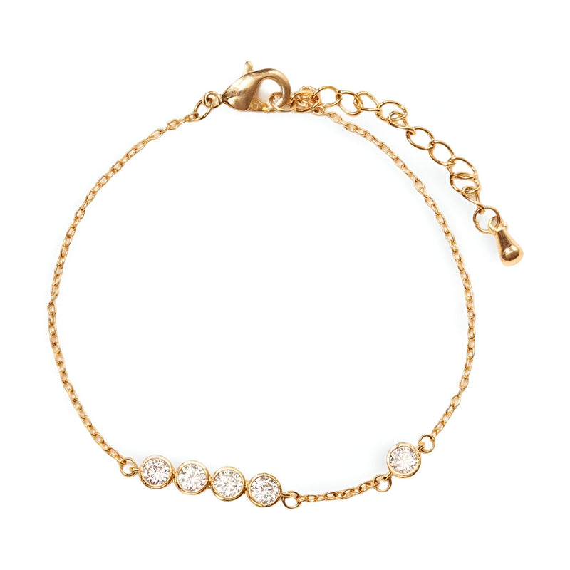 Bracelet fin en or avec sept pierres scintillantes alignées et chaîne délicate ajustable.