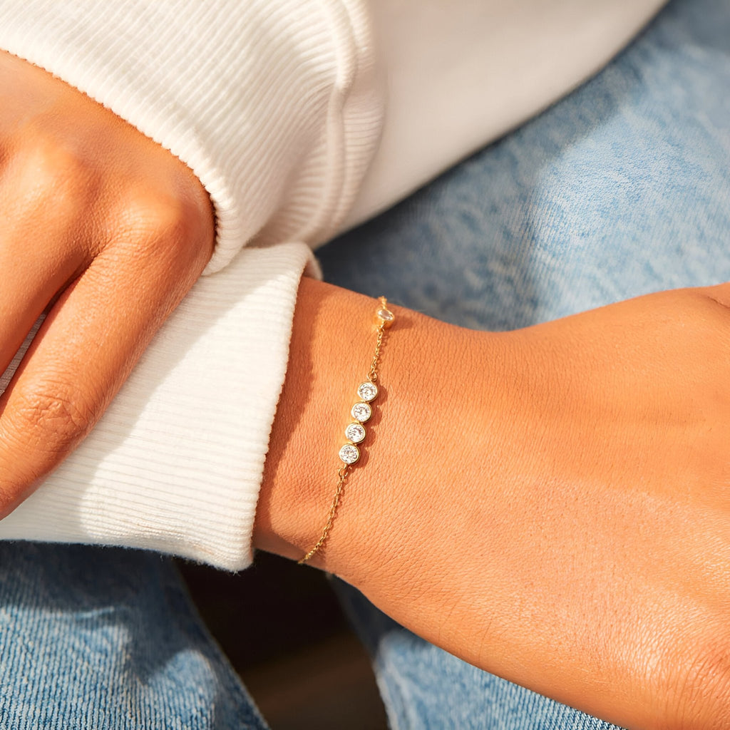 Bracelet fin en argent sterling avec trois pierres scintillantes rondes sur une chaîne délicate.
