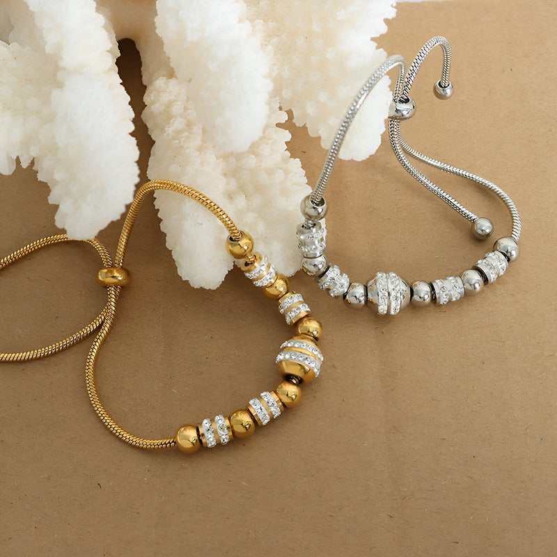 Bracelet ajustable avec perles en titane plaqué or et argent, ornées de cristaux étincelants.