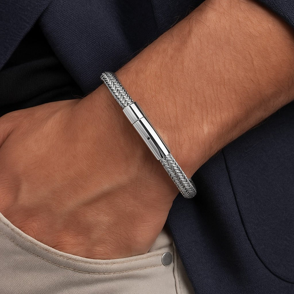 Bracelet câble en acier inoxydable argenté avec fermoir lisse porté au poignet.