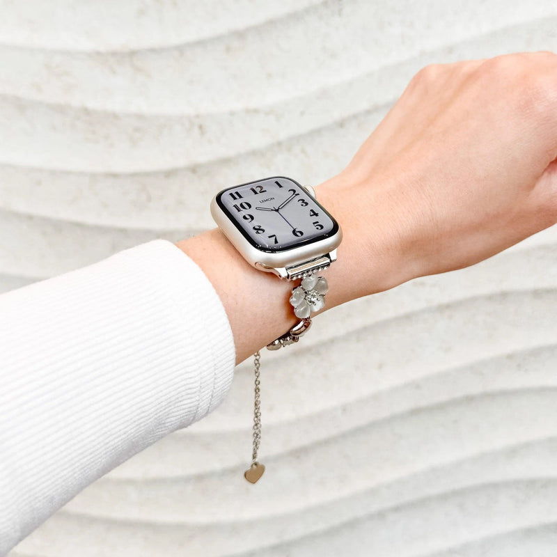 Bracelet chaîne métallique argenté avec pendentifs fleur de cerisier et cœur pour Apple Watch.