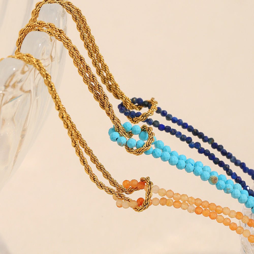 Bracelets chaîne torsadée dorée avec perles naturelles colorées bleu marine, bleu clair et corail, style élégant et raffiné.