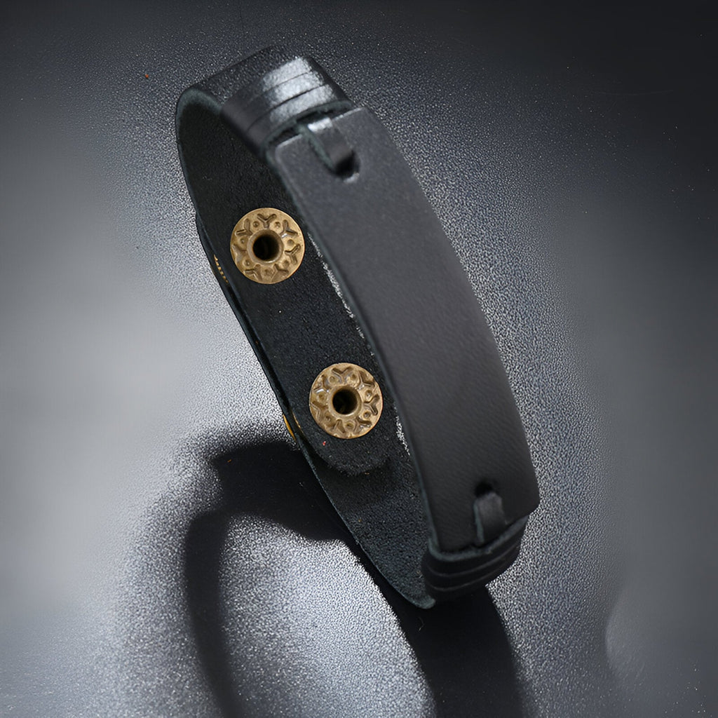 Bracelet en cuir noir effet vintage avec fermoirs circulaires en métal doré élégant.
