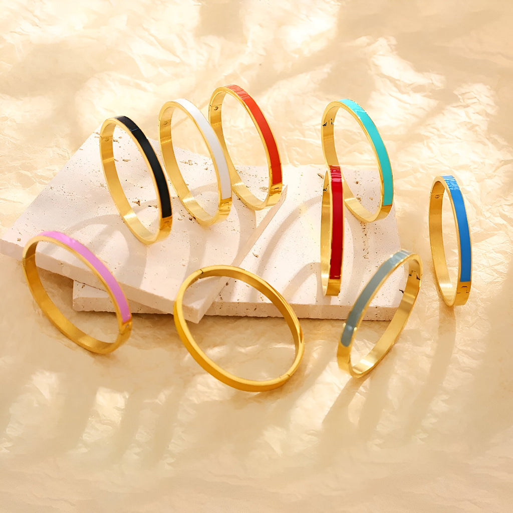 Bracelets joncs émaillés colorés en titane plaqué or, couleurs variées dont rose, noir, bleu, rouge et turquoise.