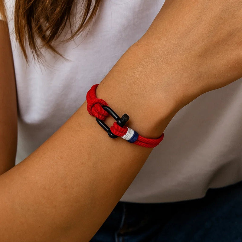 Bracelet cordon rouge avec manille noire et détail rouge et blanc élégant.