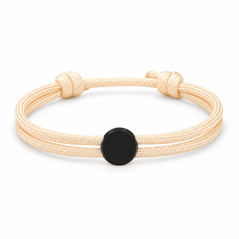 Bracelet Marsin Blanc crème et noir, cordon ajustable et pastille ronde, posé de face sur fond blanc