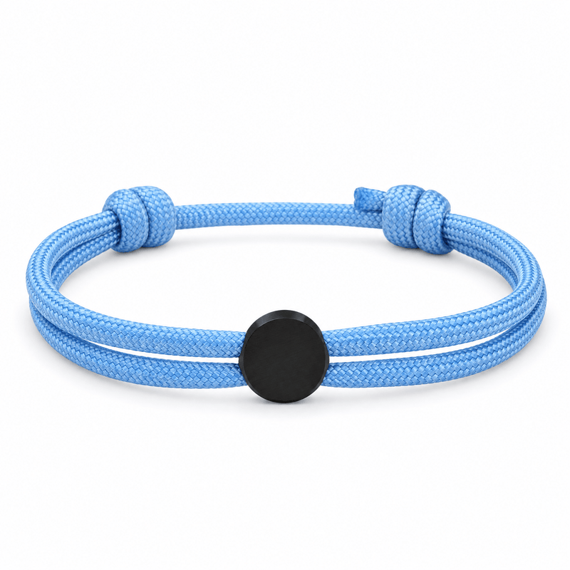 Bracelet Marsin Bleu clair et noir, cordon ajustable et pastille ronde, posé de face sur fond blanc