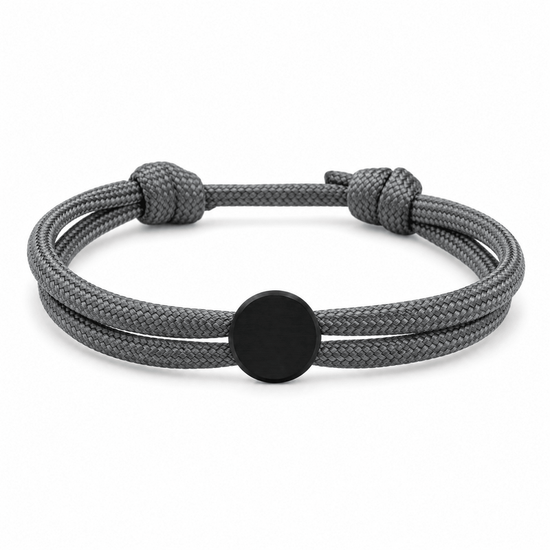 Bracelet Marsin Gris et noir, cordon ajustable et pastille ronde, posé de face sur fond blanc