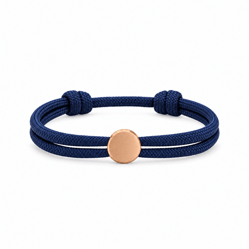 Bracelet Marsin Bleu marine et or rosé, cordon ajustable et pastille ronde, posé de face sur fond blanc