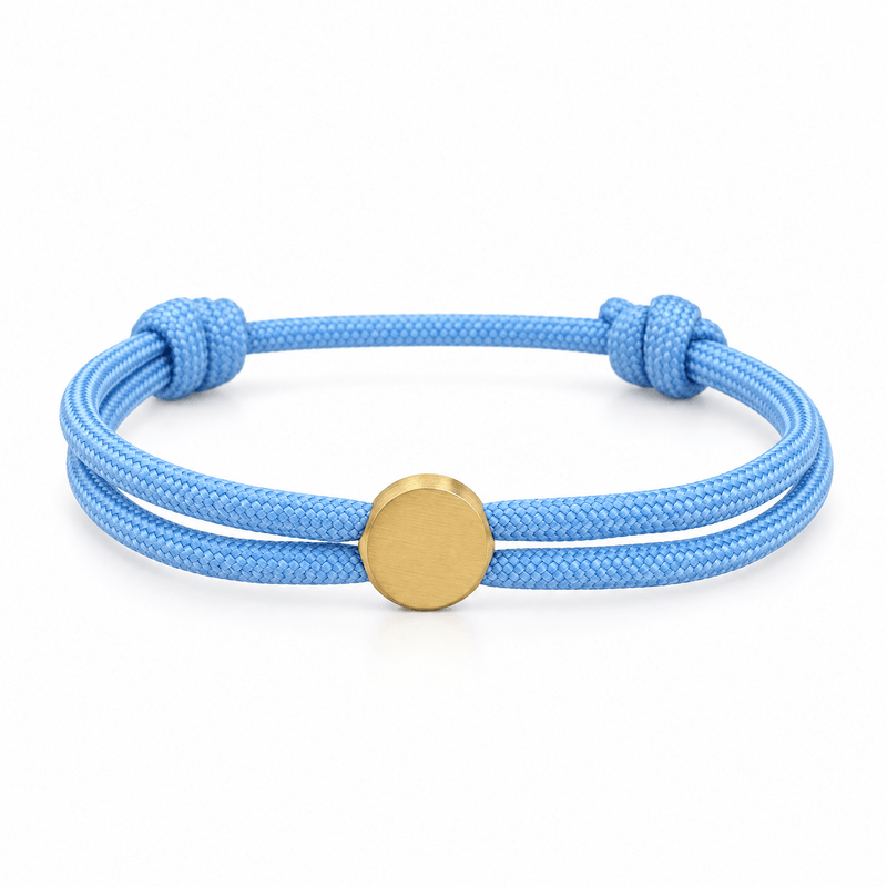 Bracelet Marsin Bleu clair et or, cordon ajustable et pastille ronde, posé de face sur fond blanc