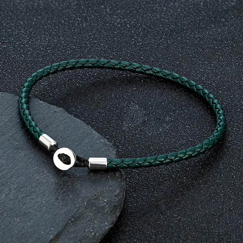 Bracelet cordon vert foncé tressé avec fermoir en métal circulaire argenté minimaliste.