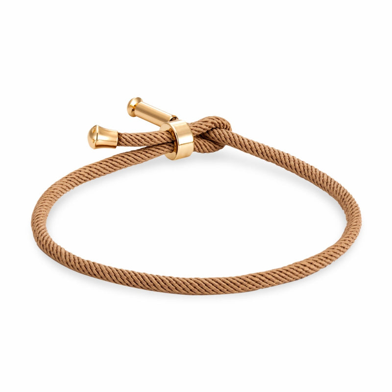 Bracelet cordon beige avec détails en titane plaqué or, fermoir minimaliste noué.