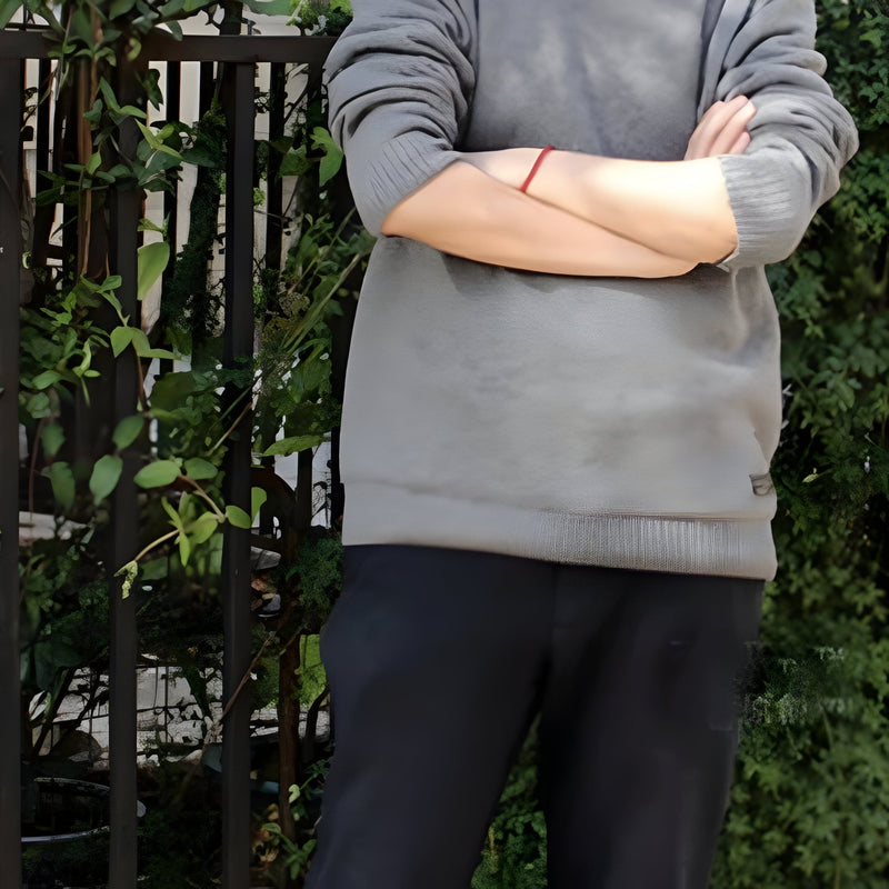 Bracelet cordon rouge fin avec pierre d'agate noire porté au poignet, style minimaliste.