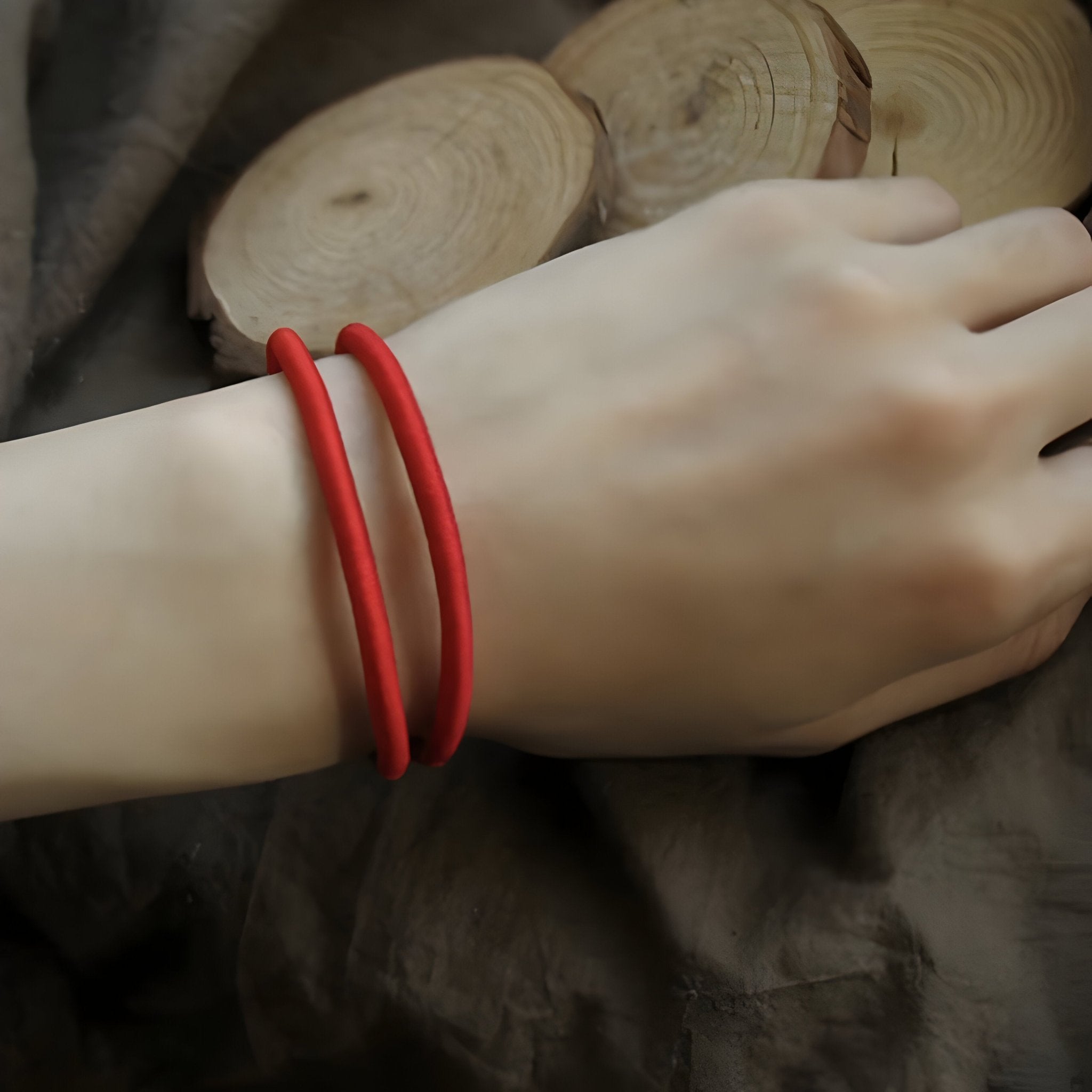 Bracelet cordon rouge double tour élégant porté au poignet féminin.