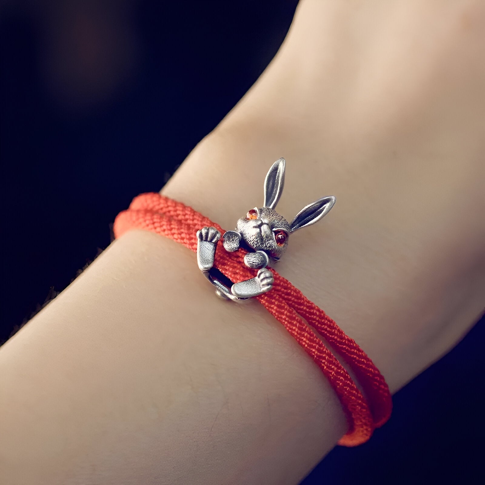 Bracelet cordon rouge avec charm lapin en métal aux yeux rouges et détail délicat.