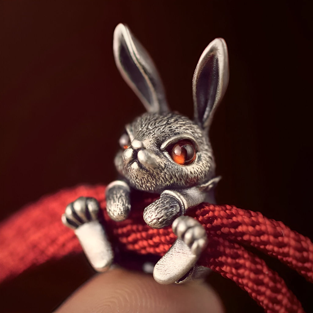 Bracelet cordon rouge avec charm lapin argenté aux yeux rouges détaillés.
