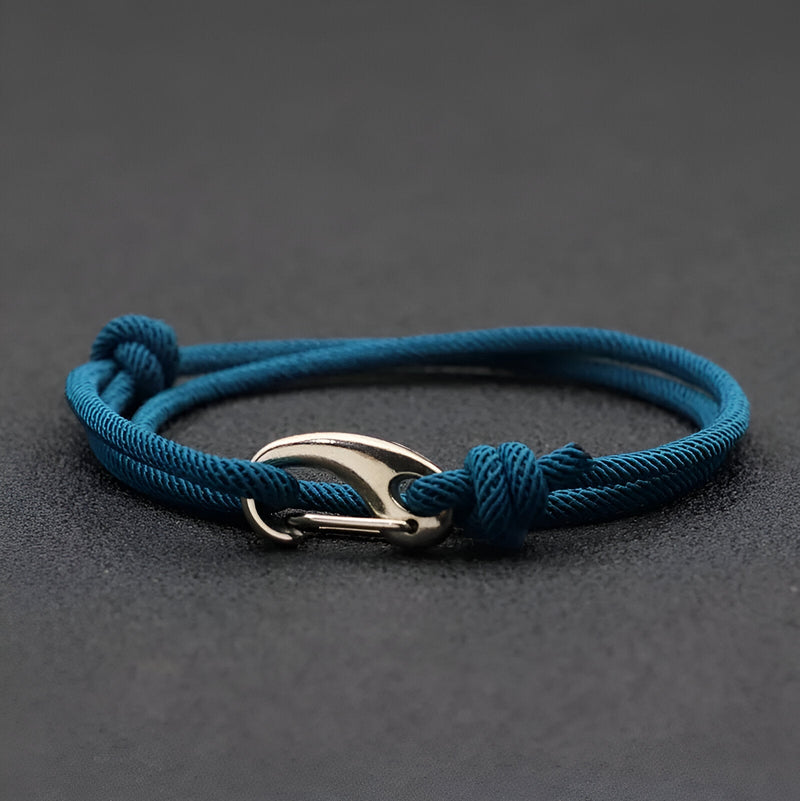 Bracelet cordon bleu marine avec mousqueton argenté et nœuds coulissants.