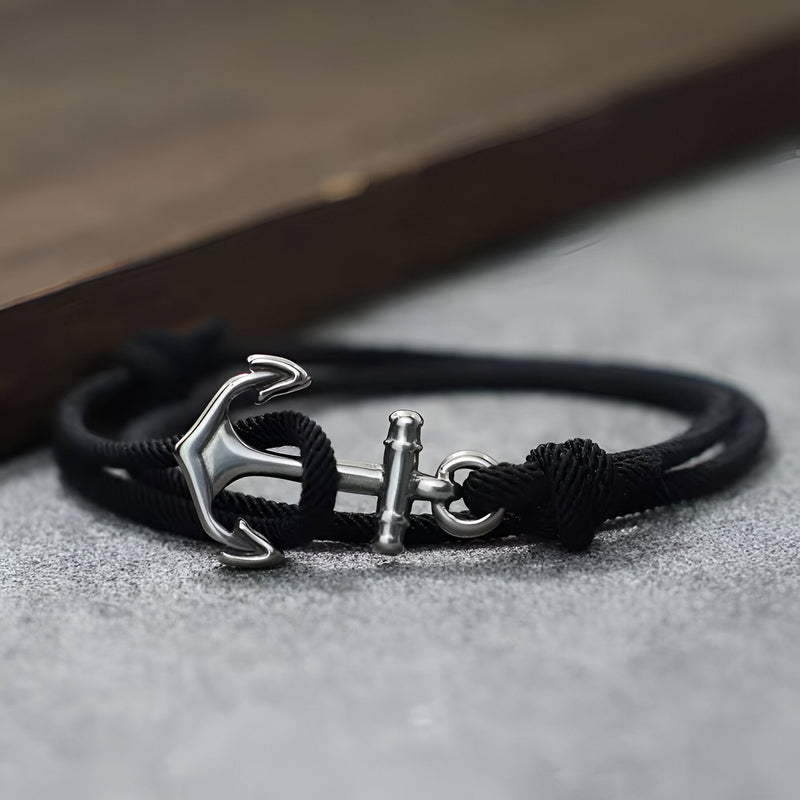 Bracelet cordon noir avec ancre marine en métal argenté et fermeture coulissante.