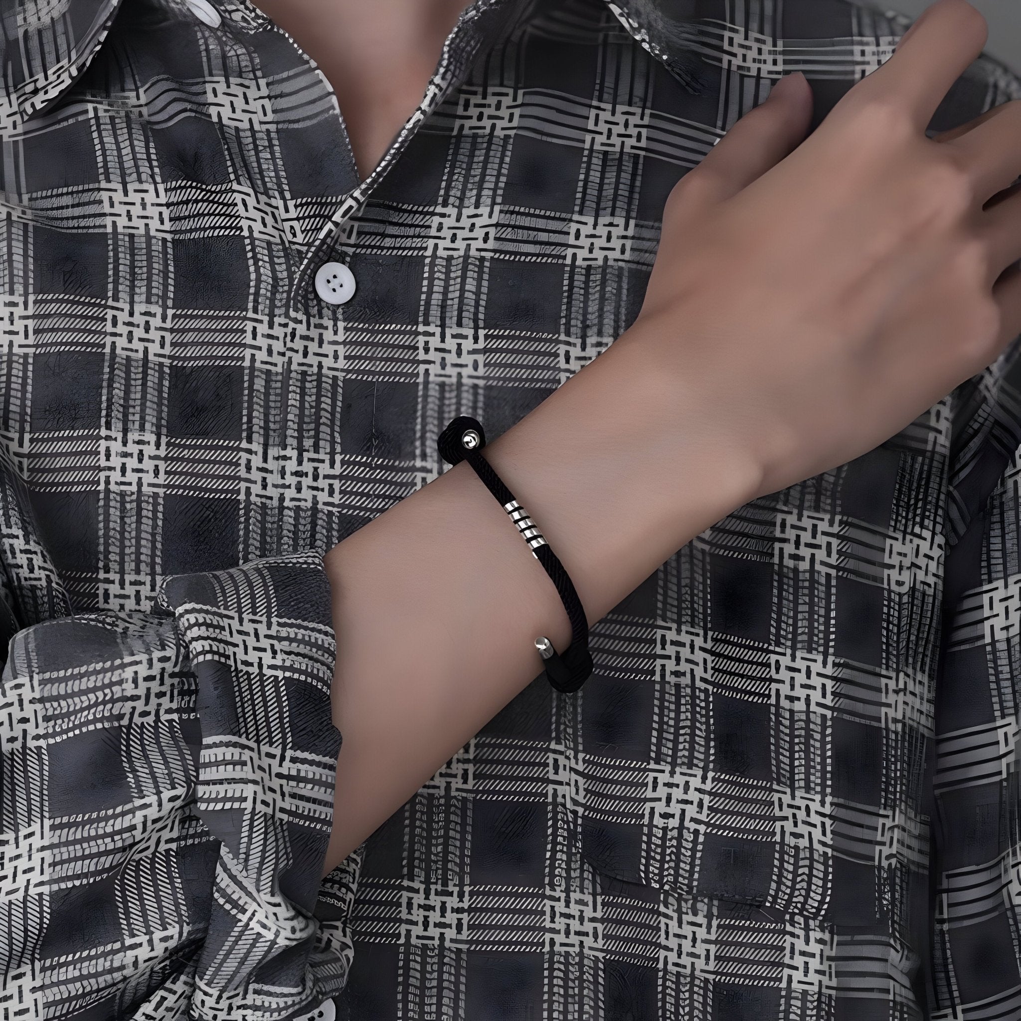 Bracelet cordon noir minimaliste avec perles en titane sur poignet masculin, style décontracté.