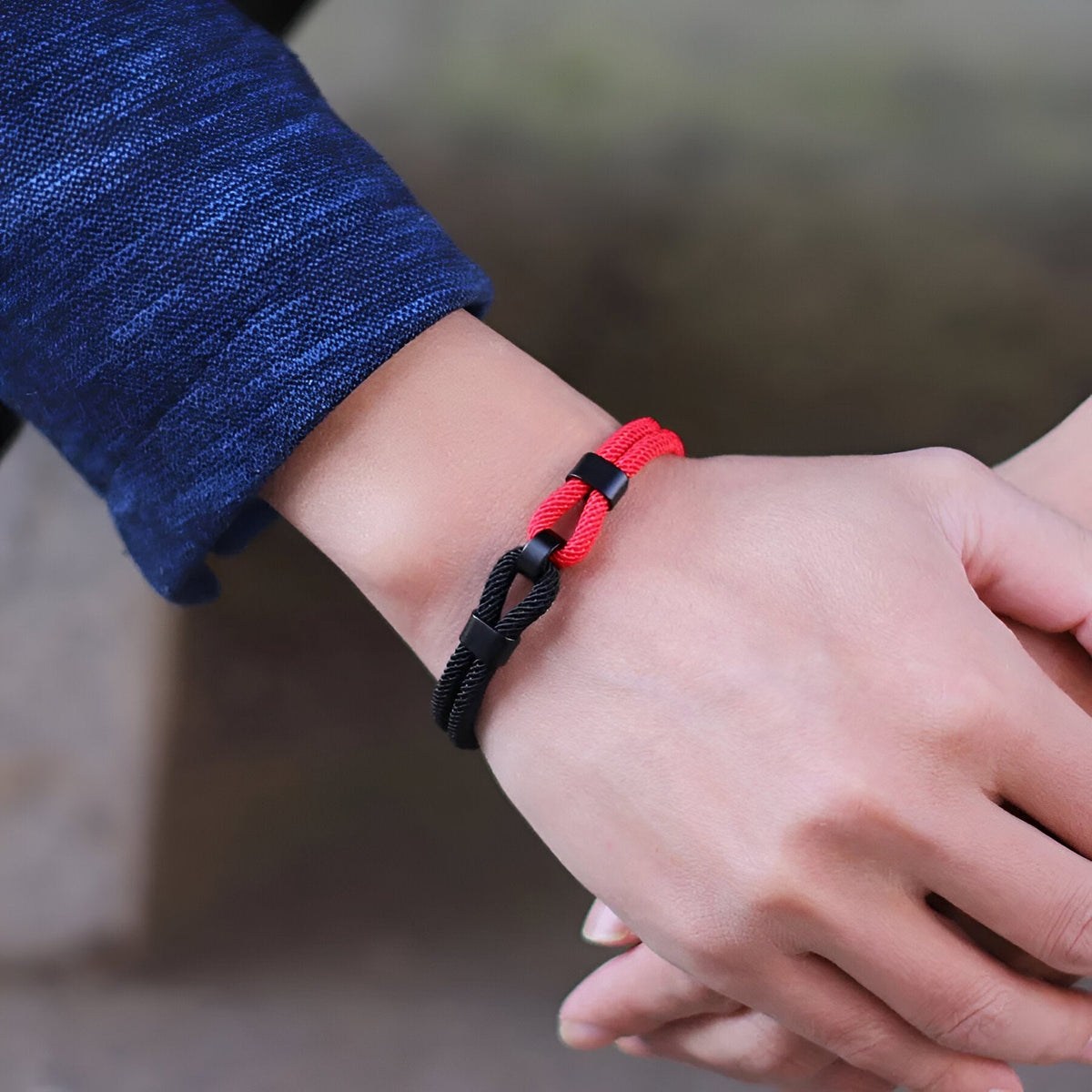 Bracelet cordon double rouge et noir à nœud pour homme avec fermeture ajustable.