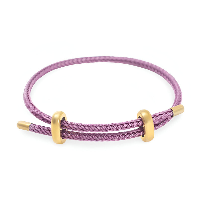 Bracelet cordon violet tressé avec détails en acier inoxydable doré élégant.
