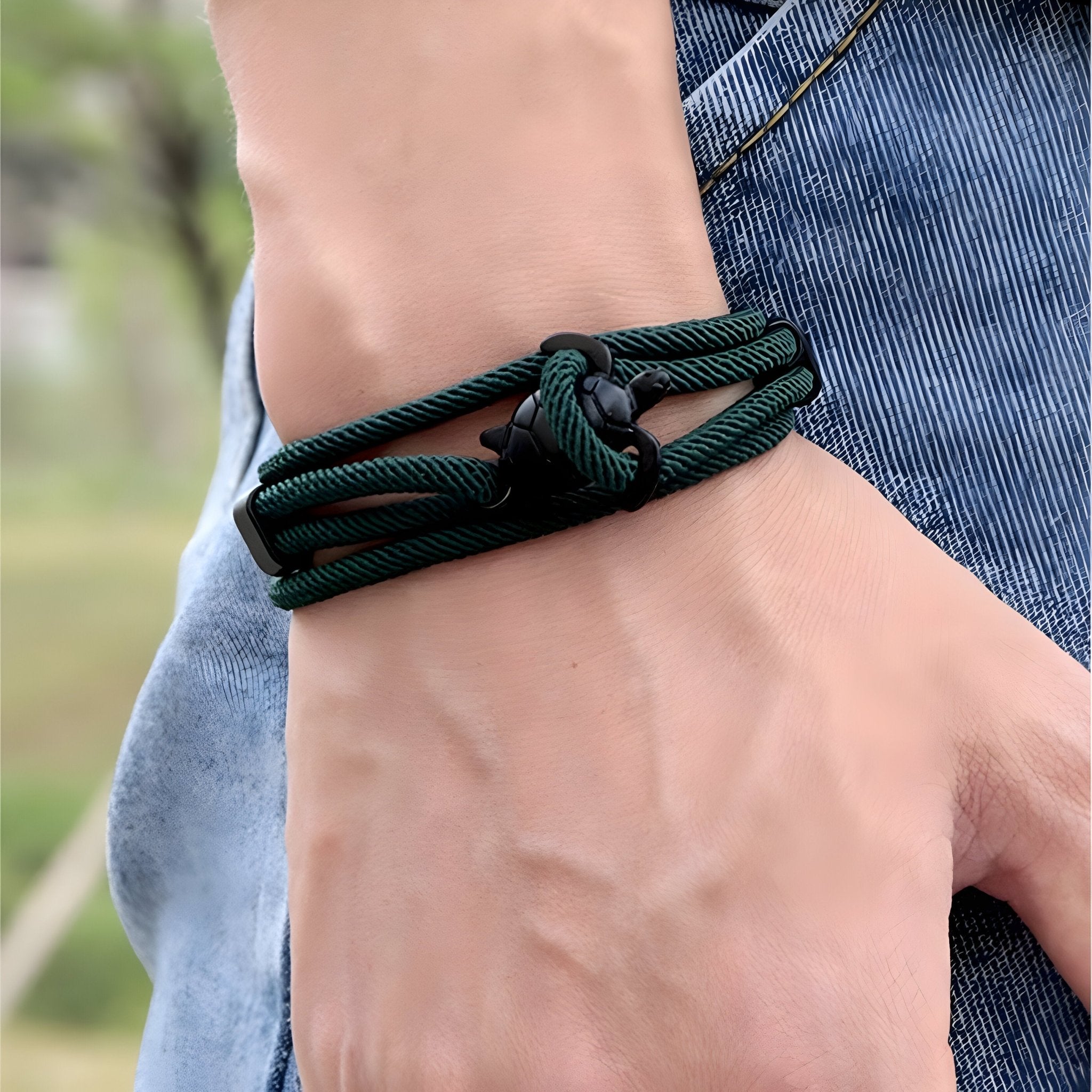 Bracelet cordon vert sapin avec motif tortue et nœud double style Franklin, porté au poignet.
