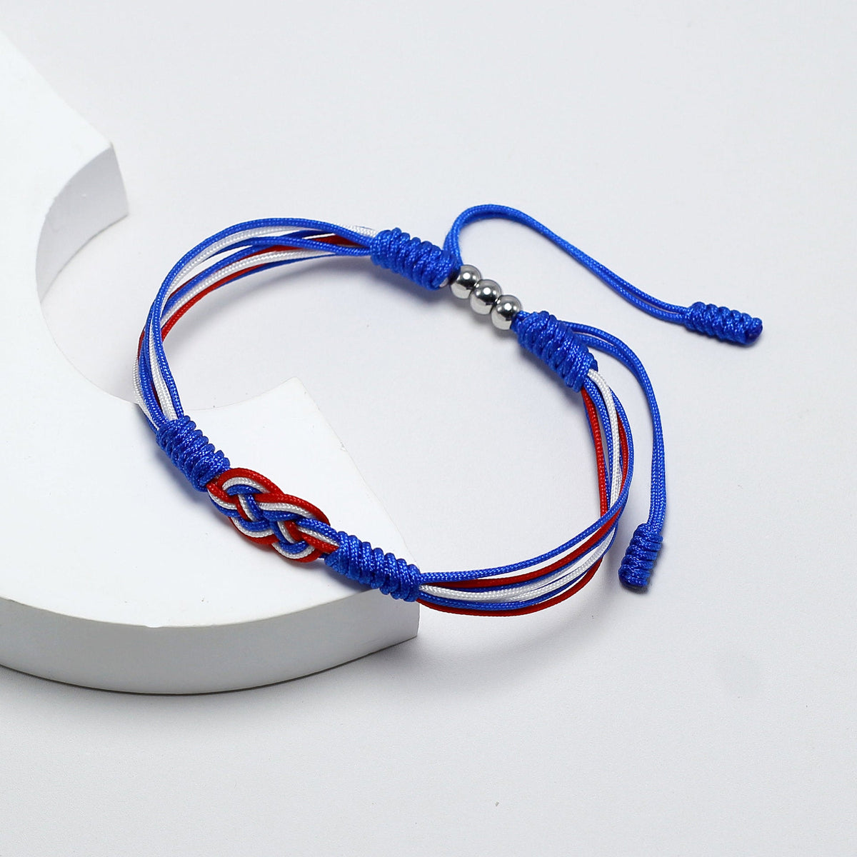 Bracelet cordon bleu et rouge avec noeud plat couleur drapeau France et fermoir métal argenté.